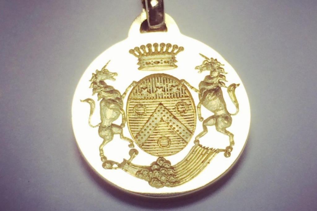 Gravure héraldique sur médaille or jaune- Gravure blason : écu de forme ovael avec couronne et support animaux