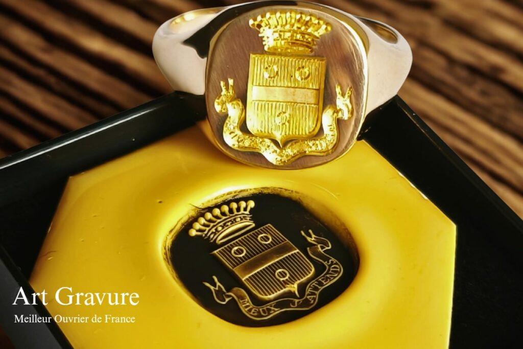“Chevalière gravée à la main avec écu héraldique, couronne et ruban de devise – Atelier Art Gravure”