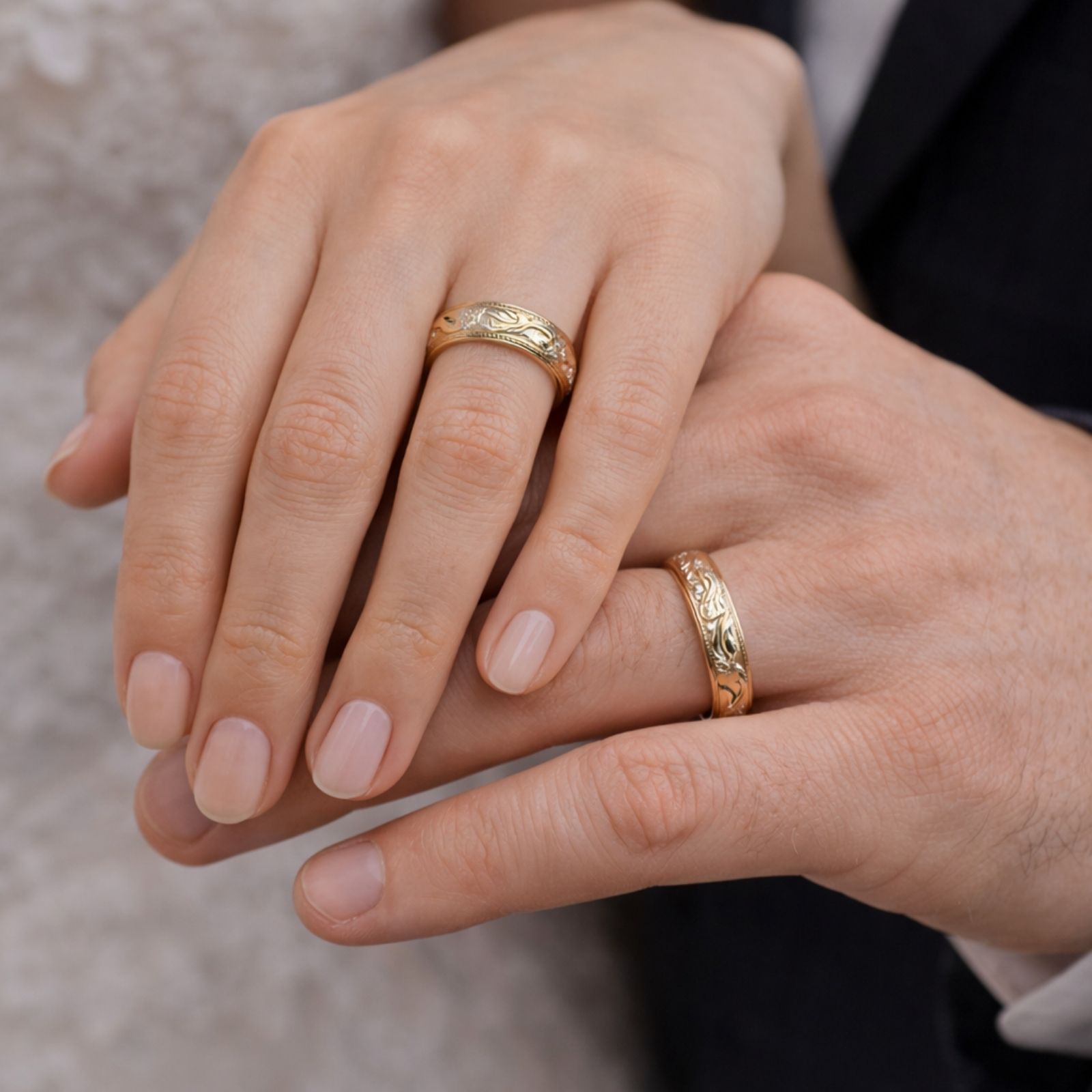 Deux alliances en or jaune personnalisées portées sur la main d’une femme et d'un homme