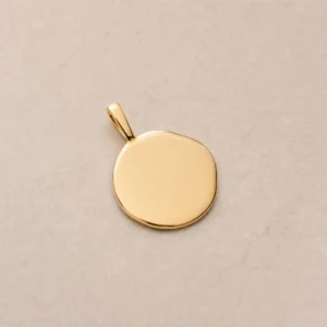 Médaille en or jaune massif à la forme organique et irrégulière, surface lisse prête à la gravure, fabrication artisanale à Tours.